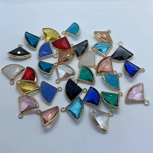 Detalle de colgantes de cristal en forma de abanico con borde metálico para joyería artesanal