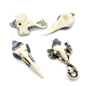 Detailed view of resin elephant skull pendants with purple crystals and rhinestones