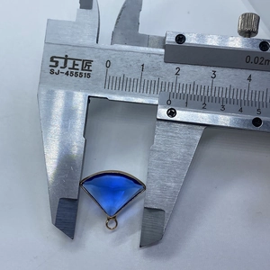 Detail view of fan-shaped blue gemstone pendant measured at 21mm with gold plating