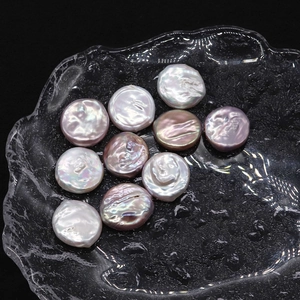Flat natural freshwater pearls in white and pink, 19-20mm loose button shape on a tray