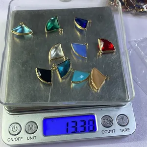 Precision scale weighing ten pieces of faceted natural stone pendants with gold metal edging