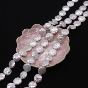 Primer plano de perlas naturales blancas en forma de moneda con brillo en plato rosa