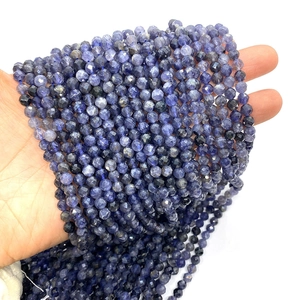 Faceted iolite natural stone beads 6mm for DIY jewelry making held in hand on white background