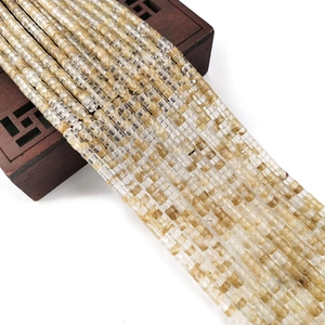 Gouden rutielkwarts kralen 2x4mm gedrapeerd op een vintage donkerhouten sieradendoosje