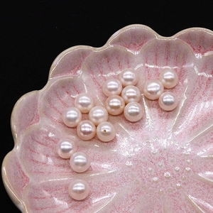 Macro de perles d'eau douce naturelles blanc-rosé de 8mm à haute brillance sur coupelle