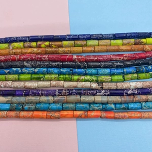 Macro view of twelve colorful cylindrical 4x8mm natural emperor stone beads for DIY jewelry