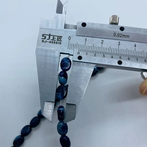 Detail showing an oval emperor stone bead measured with a caliper at 10mm width
