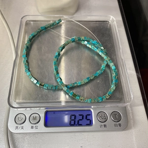 Macro detail of natural turquoise square beads on a scale showing 8.25g weight
