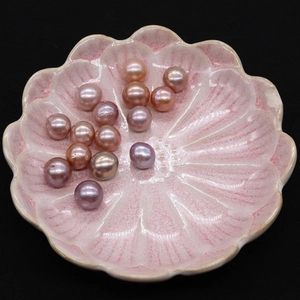 Macro shot of colorful 9-14mm Edison freshwater pearls in a pink ceramic petal tray