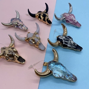 Detail of assorted bull head pendants in diverse colors with golden metallic framing