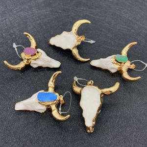 Detailed view of bull skull pendants with colorful crystals and golden frames