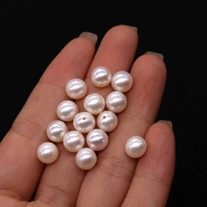 White freshwater pearl loose beads with natural luster shown on hand for DIY jewelry
