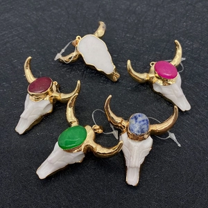 Detail of five bull head skull pendants with colorful stones and gold metal trim