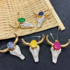 Bull head skull pendants with colorful gemstones and golden horns set in a bamboo basket
