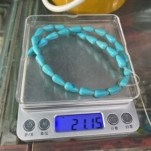 Macro de perles de turquoise bleue en forme de goutte pesant 21,15 g sur une balance