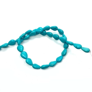 Flat lay of teardrop-shaped blue turquoise natural stone beads for DIY jewelry making