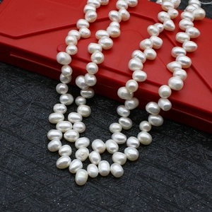 Macro detail showing high-luster natural freshwater pearls on a red and black jewelry box