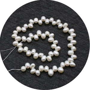 Natural white freshwater pearls strand with high luster on black textured background