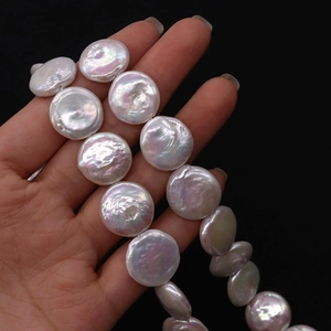 Macro detail of high luster 15-20mm coin-shaped natural freshwater pearls on hand