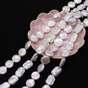Macro shot of natural Keshi freshwater pearls with iridescent luster on pink shell plate