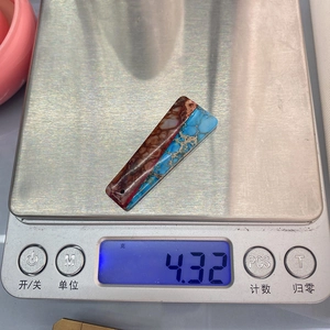 Macro di un ciondolo trapezoidale in pietra imperiale da 4,32g su una bilancia digitale