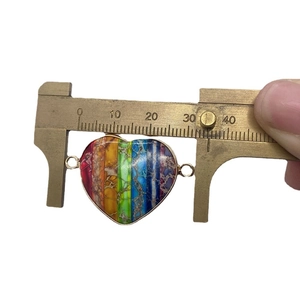 Rainbow emperor stone heart pendant with dual loops measured by brass caliper