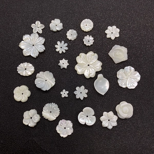 Natural white shell flower and leaf beads for DIY jewelry making on black background