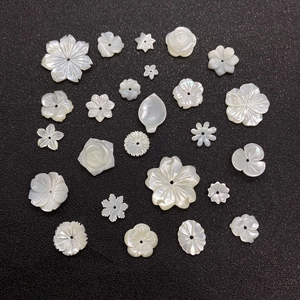 Detailed macro of white natural shell flower beads and leaf shapes for DIY jewelry making