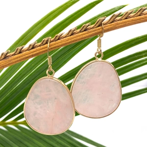 Natural teardrop rose quartz earrings with gold-plated trim hanging on a branch