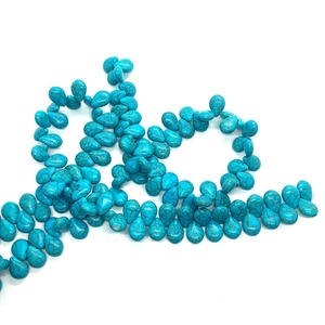 Macro detail of blue turquoise teardrop beads with natural brown mesh texture for jewelry