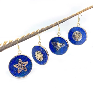 Lapis lazuli round earrings with gold plating and butterfly charms on wooden branch