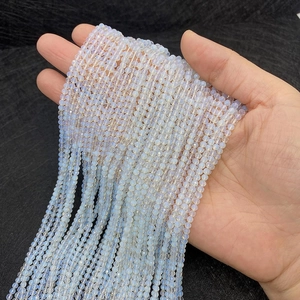 Détail macro de perles d'opale facettées montrant l'éclat bleu et la coupe de précision