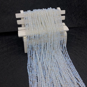 Vue détaillée de perles d'opale facettées aux reflets bleus sur support en bois