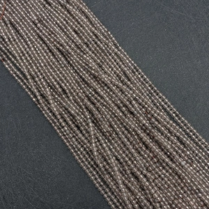 Macro detail van gefacetteerde rookkwarts kralen met precieze slijpvorm en grijze textuur