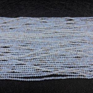 Vue macro de perles d'opale laiteuse facettées avec reflets bleus pour la création de bijoux