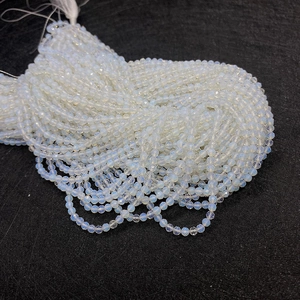 Détail macro de perles en pierre naturelle facettée blanc laiteux pour bijoux DIY