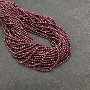 Makroaufnahme mehrlagiger facettierter tiefroter Granat-Loseperlen für DIY-Schmuck