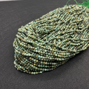 Macro view of 2-3mm faceted African Turquoise beads with natural mineral textures