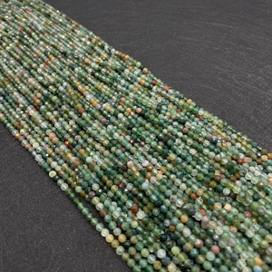 Macro shot of 2mm faceted Indian agate beads in shades of green for jewelry making