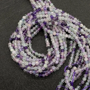 Close-up of faceted natural fluorite beads in purple and green shades for jewelry