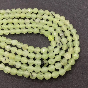 Macro shot of faceted prehnite beads with natural mineral inclusions on a black background