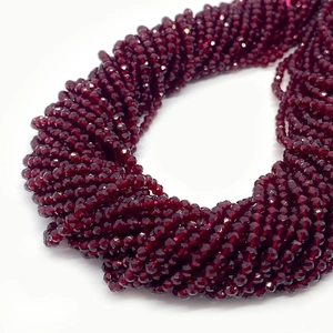 Macro detail of 2-3mm faceted deep red spinel glass beads for DIY jewelry making
