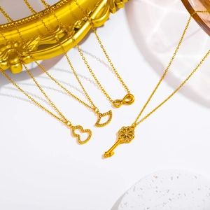 Macro shot of gold plated titanium steel necklaces with key, heart, and fan pendants