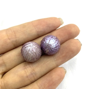 Macro detail of pair of carved purple freshwater dragon scale pearls with unique textures