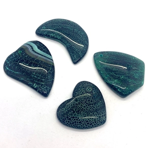 Detailed view of green dragon vein agate pendants in moon, heart, and teardrop shapes
