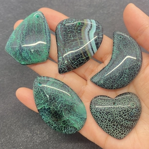 Macro detail of polished green dragon vein agate pendants in various geometric shapes