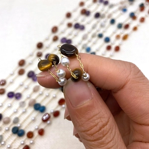 Detail of tiger eye and pearl bead gold chain with exquisite handmade jewelry texture