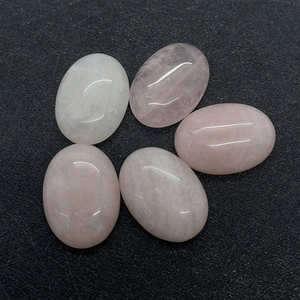 Macro-opname van vijf gepolijste ovale rozenkwarts cabochons met natuursteen texturen