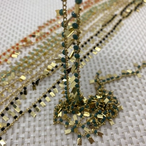 Makro-Detail der Naturstein-Perlenkette mit goldenen Pfeilanhängern für DIY-Schmuck
