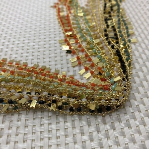 Detailaufnahme einer Goldkette mit bunten Kristallperlen und Pfeilanhängern für DIY-Schmuck